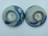 two blue and white vases sitting on a white surface