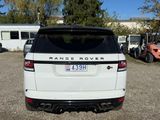 a white range rover parked in a lot with other vehicles