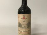 une vieille bouteille de vin posée sur une table blanche