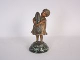 bronze figurine of a girl holding a bird on a marble base