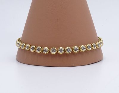 un gros plan d'un bracelet en or et diamants sur un mannequin