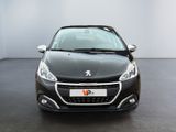 the front view of a black car in a room with a white wall