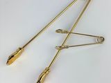 a pair of gold tone hair pins on a white background