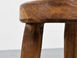 close up of a wooden stool with a wooden seat on a gray surface