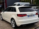 a white audi car parked in front of a building