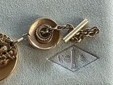 an image of a gold plated keychain with a skull and crossbone on it