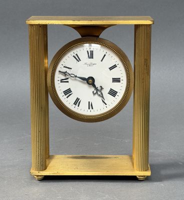 a gold clock with roman numerals on the face