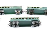 five miniature trains on a white surface with one train in the middle