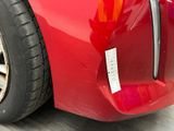 a close up of a red car with a sticker on it ' s bumper