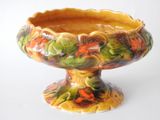 a yellow and green vase on a white surface