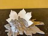 une feuille d'argent posée sur une table, avec un mur jaune en arrière-plan