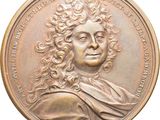 une image d'une médaille de bronze représentant un homme aux cheveux bouclés