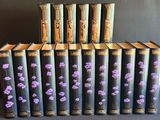 six vieux livres ornés de fleurs violettes, posés sur une table