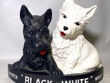 deux figurines de chiens en noir et blanc assises l'une à côté de l'autre