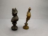 two figurines of a man and a woman on a pedestal