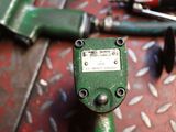 a close up of a green drill head on a metal floor