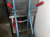 un diable bleu posé à côté d'un carton
