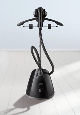 une photo d'un fer à repasser à vapeur noir posé sur un parquet