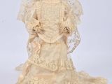 an antique doll of a woman wearing a wedding dress and veil
