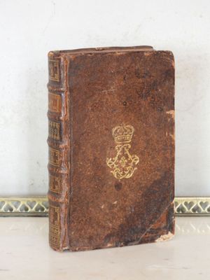 un vieux livre orné d'une couronne, posé sur une table