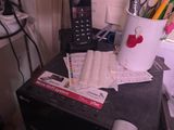 un pot rempli de crayons et un téléphone portable posés sur un bureau
