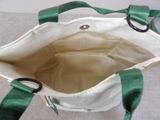a green and white bag with a pair of scissors in it