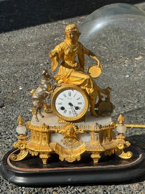 une horloge en or posée sur un socle en marbre