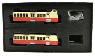 deux trains miniatures dans une boîte noire sur fond blanc