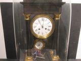 a glass case with a clock inside of it on a table