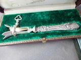a silver knife in a green velvet case on a table
