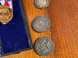a small box with coins and a medal on a table
