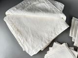 several white napkins and napkins on a table with a pair of scissors