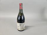 an old bottle of wine sitting on top of a table