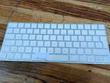 a white keyboard sitting on top of a wooden table