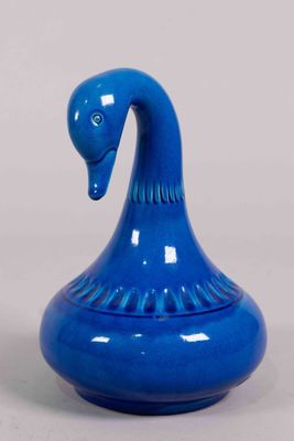 un vase bleu surmonté d'un oiseau