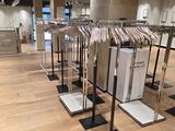a lot of clothes hanging on racks in a store