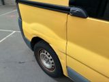 a yellow van parked in a parking lot next to a building