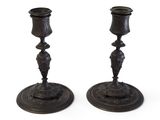 paire de bougeoirs anciens en bronze, dont les socles sont ornés de motifs élaborés
