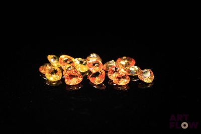 three yellow sapphires are sitting on a black surface