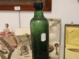 a green glass bottle sitting on top of a table