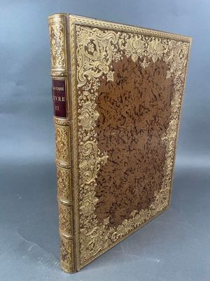un vieux livre avec une couverture dorée sur fond gris