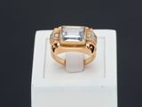 un gros plan d'une bague en or sertie d'une pierre blanche