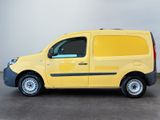 the yellow van is parked in the parking lot near the wall