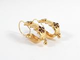 a pair of gold earrings with black stones on them