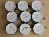 six coffee cups with writing on them sitting on a table