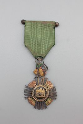 une image représentant une médaille ornée d'un ruban vert et d'un oiseau