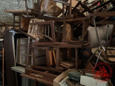 un gros tas de meubles dans une pièce aux murs en briques