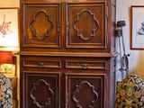 une photo d'un salon avec une grande armoire en bois