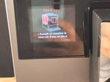 a person taking a picture of a coffee machine