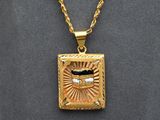 an image of a gold necklace with a picture of a man